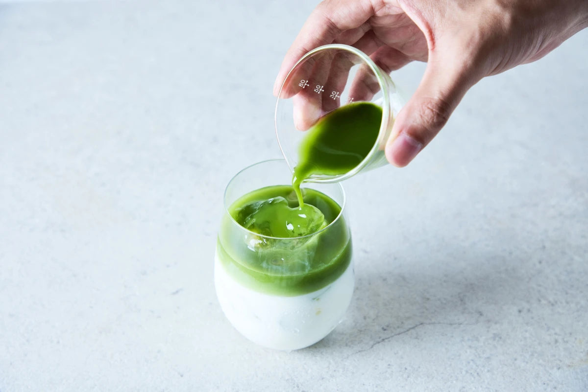 ミルクに挽き茶を注いで仕上げる、二層の挽き茶ラテ