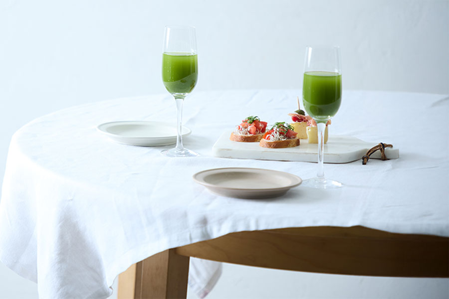 白いテーブルに料理と並べた、ワイングラス入りの挽き茶